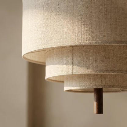 Pendellampa i ljus naturfärgad textil tänd med dimbar LED