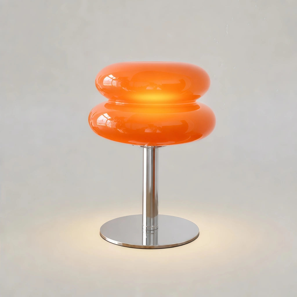 Vit bordslampa i glas och metall på nattduksbord i sovrum