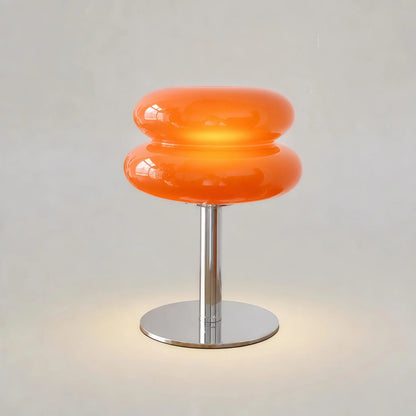 Vit bordslampa i glas och metall på nattduksbord i sovrum