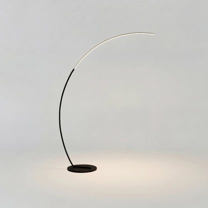 Bågformad golvlampa i pulverlackerad aluminium som böjer sig över en soffa