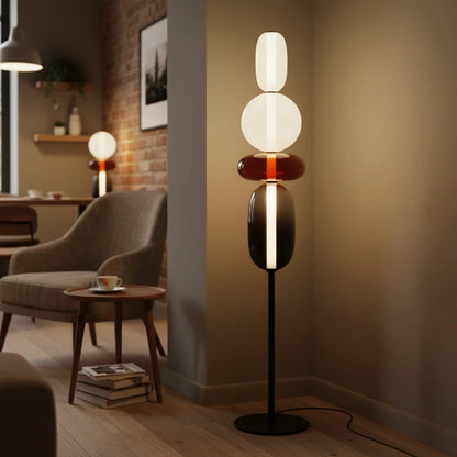 Golvlampa i glas och metall tänd i ett sovrum