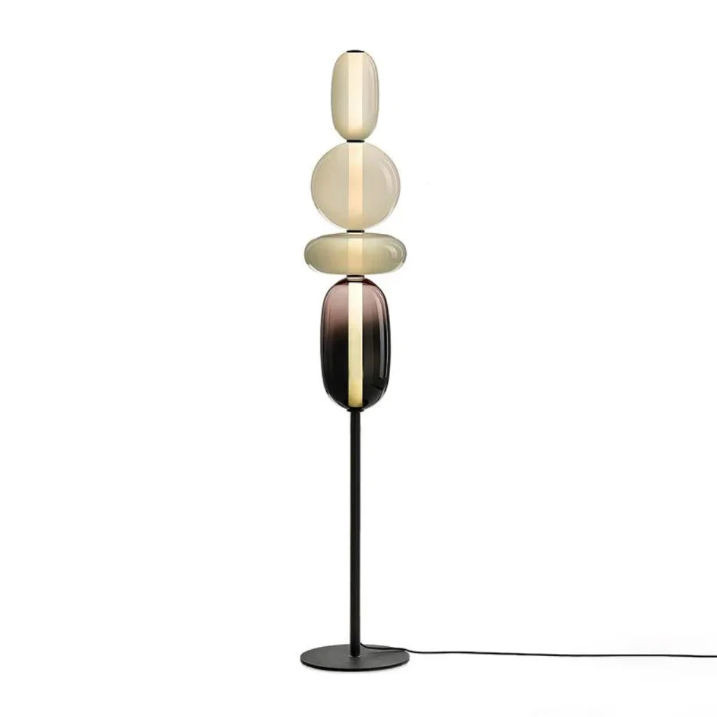 Munblåst glasskärm på golvlampa som sprider varmt ljus