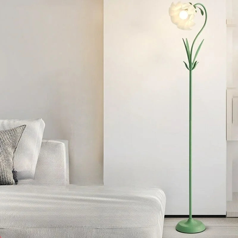 Grön golvlampa med tulpanform tänd bredvid en fåtölj