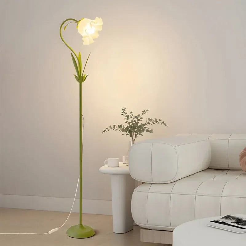 Golvlampa med blomformad skärm i akryl sedd från sidan