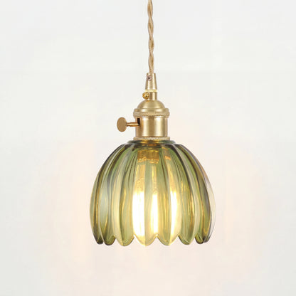 Blomformad pendellampa i glas som lyser med varmt diffust ljus
