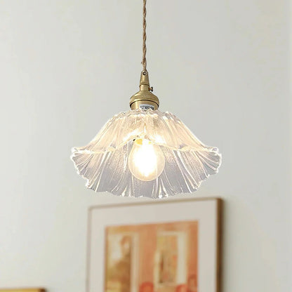 Pendellampa Lotus i munblåst glas med kopparfäste, tänd över matbord