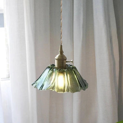 Pendellampa i transparent glas tänd över köksö