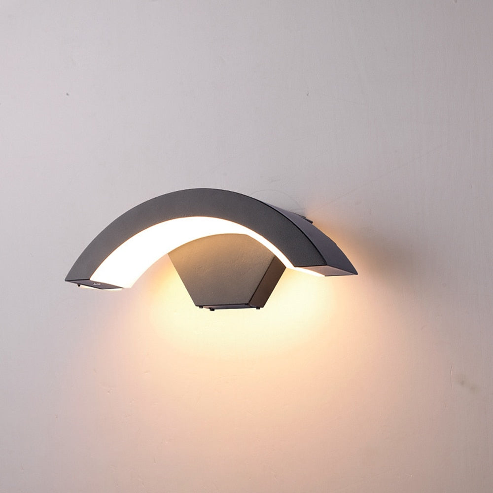 Närbild på bågformad utomhusvägglampa i svart