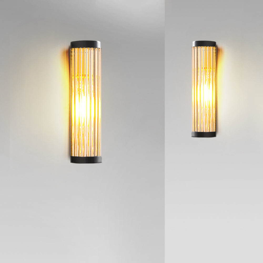 Utomhusvägglampa i räfflat glas med varmt sken vid entrén