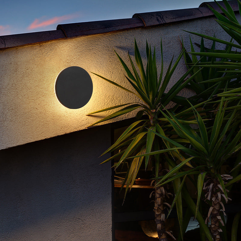 Närbild på rund utomhusvägglampa i metall