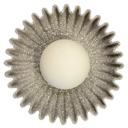 Närbild på blomformad keramikvägglampa och akrylkupa