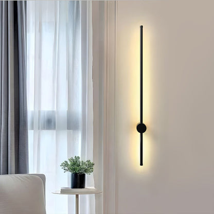 Vägglampa i aluminium tänd med trefärgat ljus