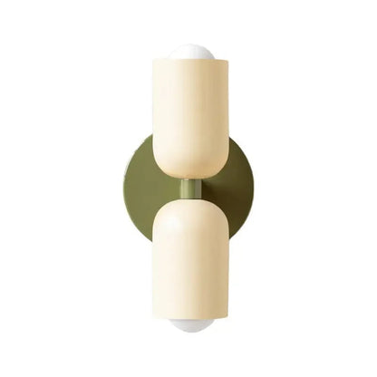 Vägglampa i metall med mjuk pastellton och rund form