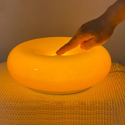 Rund vägglampa i orange glas med mjukt varmt LED-ljus