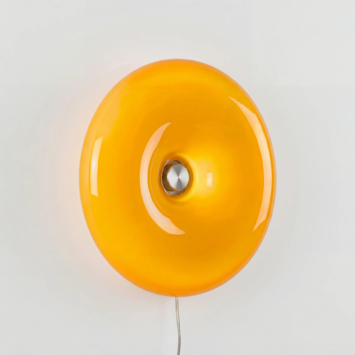 Vägglampa med rund glaskupa tänd på vägg i sovrum