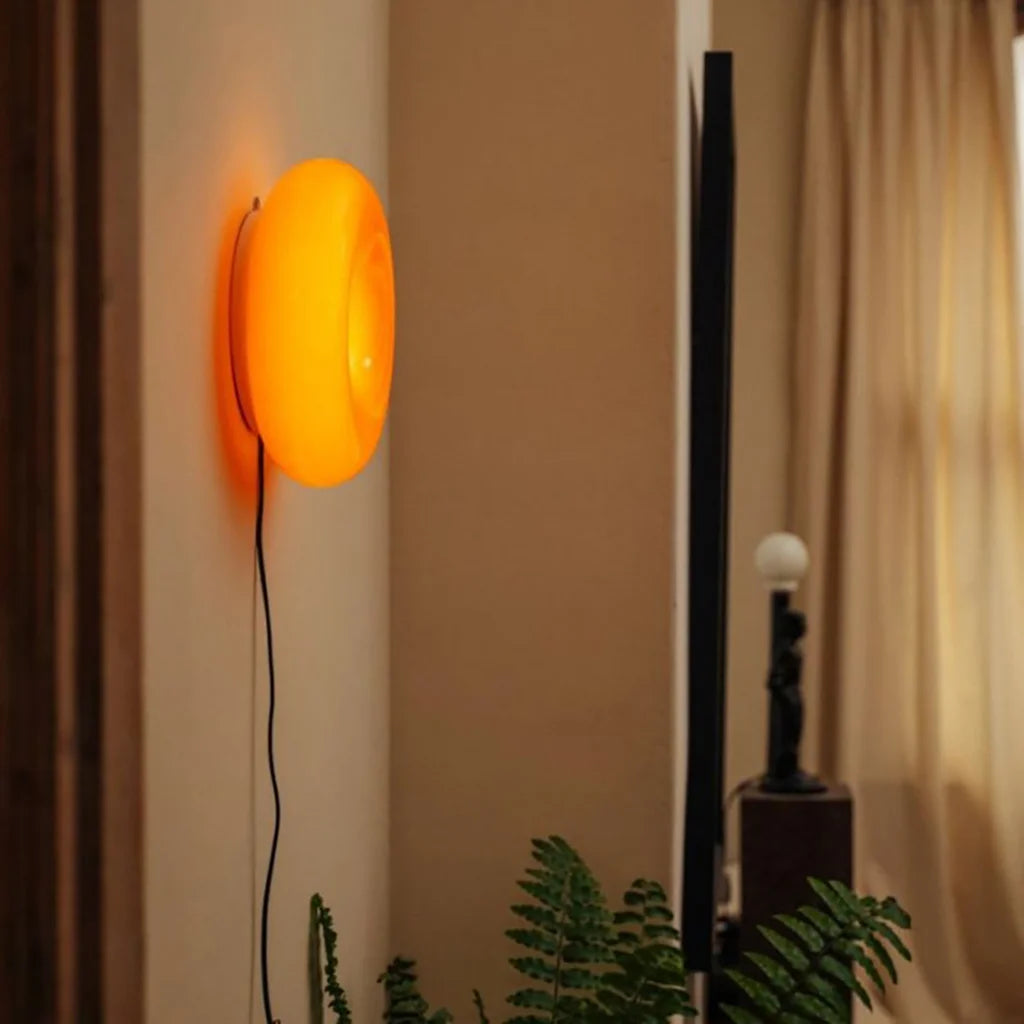Orange och vit rund vägglampa i glas sida vid sida