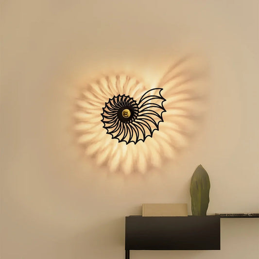 Vägglampa med snäckdesign i keramik och metall, svart finish