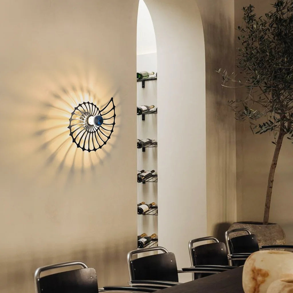 Vägglampa i snäckdesign sedd från sidan med tydlig profil